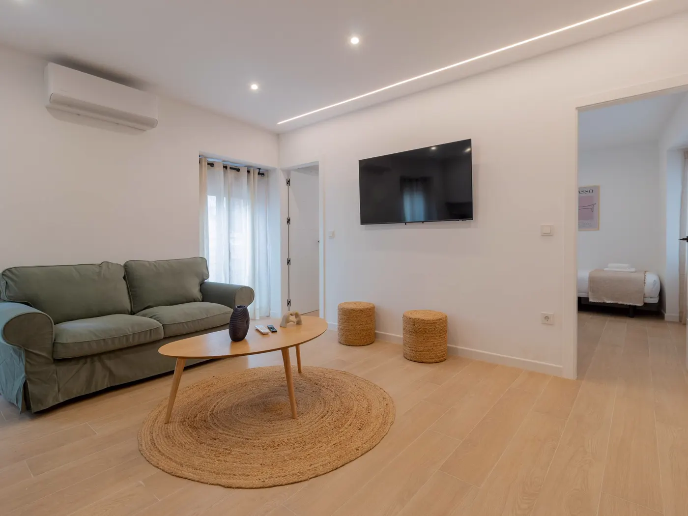 Salón con sofá verde y alfombra de yute