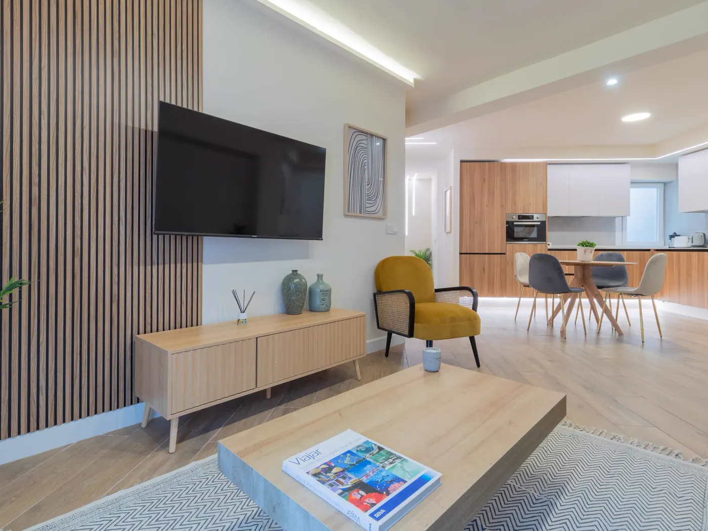 Salón con listones de madera y cocina abierta